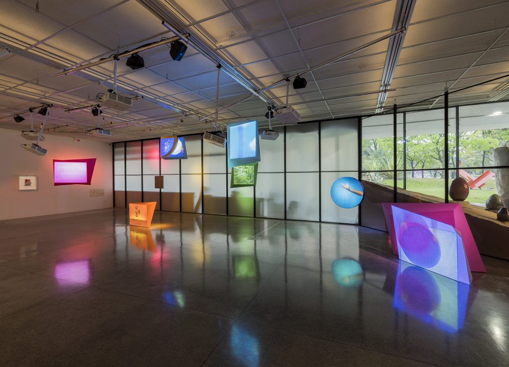 Instalação Manifestação Revolução Mística, de Rodrigo Cass, com telas coloridas e projeções luminosas no Panorama da Arte Brasileira.